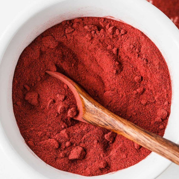 ASTAXANTHIN in a white bowl with a wooden spoon